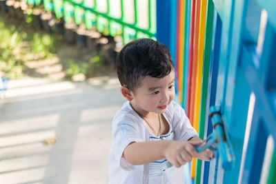 Smiling boy locking park gate