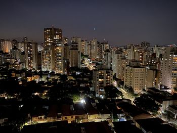 Illuminated buildings against sky at night