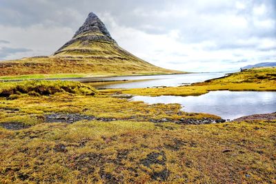 Scenic view of lake against cloudy sky