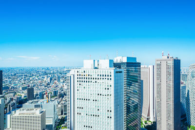 Modern buildings in city against blue sky