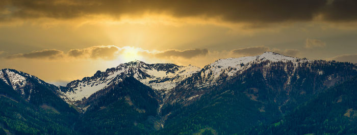 Scenic view of snowcapped mountains against sky during sunset