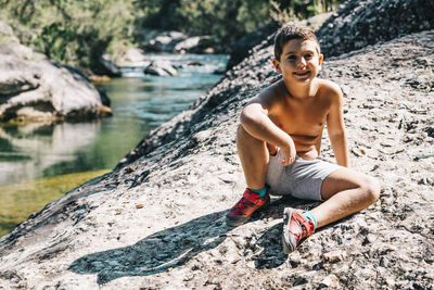 Portrait of teenage girl sitting on rock