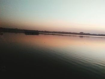 Scenic view of lake against clear sky during sunset