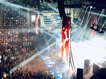 Panoramic view of crowd at music concert at night