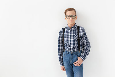 Portrait of smiling young man standing against white background