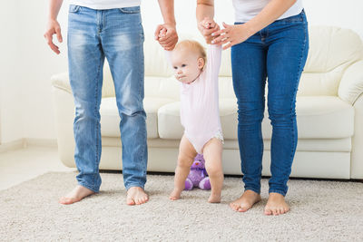 Low section of parents holding baby at home