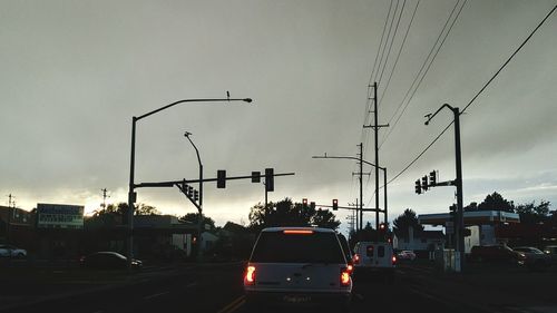 Cars on road against sky during sunset