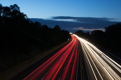 Light trails on road against sky at night