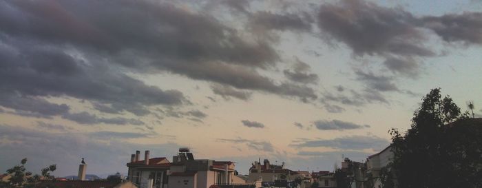 Low angle view of cityscape against dramatic sky