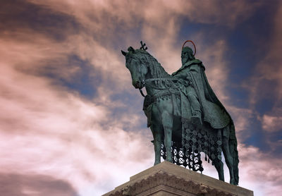 Low angle view of angel statue against cloudy sky