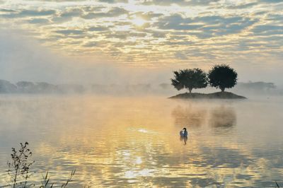 Scenic view of lake against sky during sunset