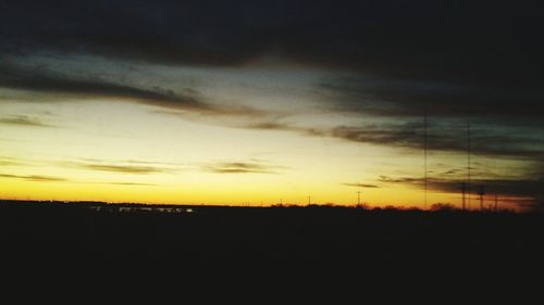 Scenic view of silhouette field against sky at sunset