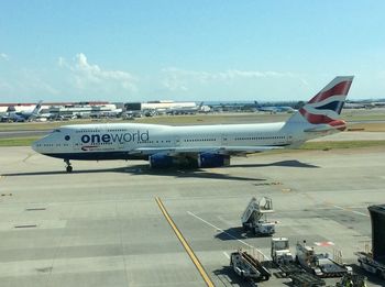 Airplane on airport runway against sky