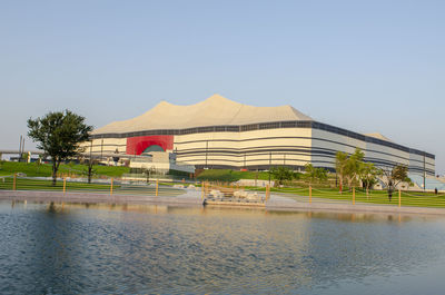 Building by lake against clear sky