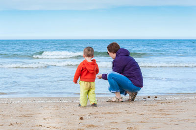 Rear view of woman with son at beach
