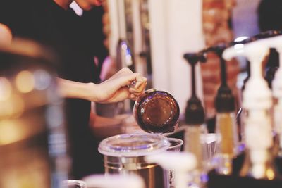 Close-up of hand pouring wine in glass