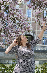 Portrait of a beautiful plump caucasian confident woman in magnolia flowers