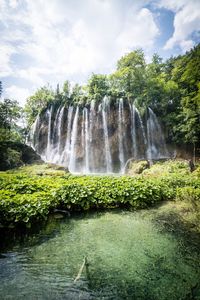 Scenic view of waterfall against sky