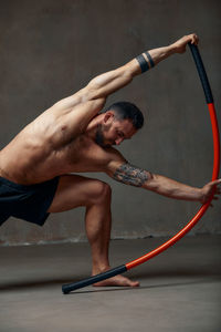 Full length of man exercising against wall