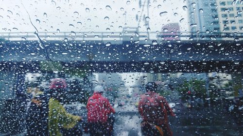 Cars on road seen through wet window in rainy season