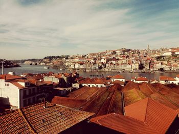 High angle view of town by sea against sky