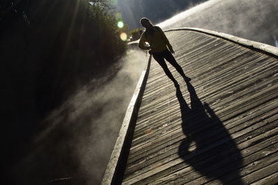 High angle view of man climbing on wood against sky