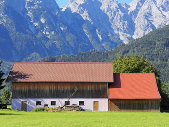 Houses on field against mountain range