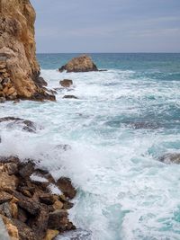 Scenic view of rocks in sea against sky