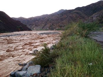 Scenic view of land and mountains against sky