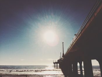 Low angle view of sun shining over sea