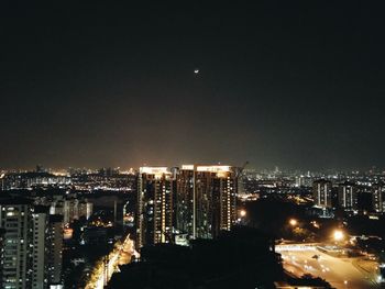 Illuminated cityscape against sky at night