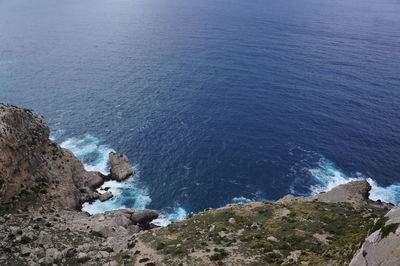 High angle view of rocks by sea against sky