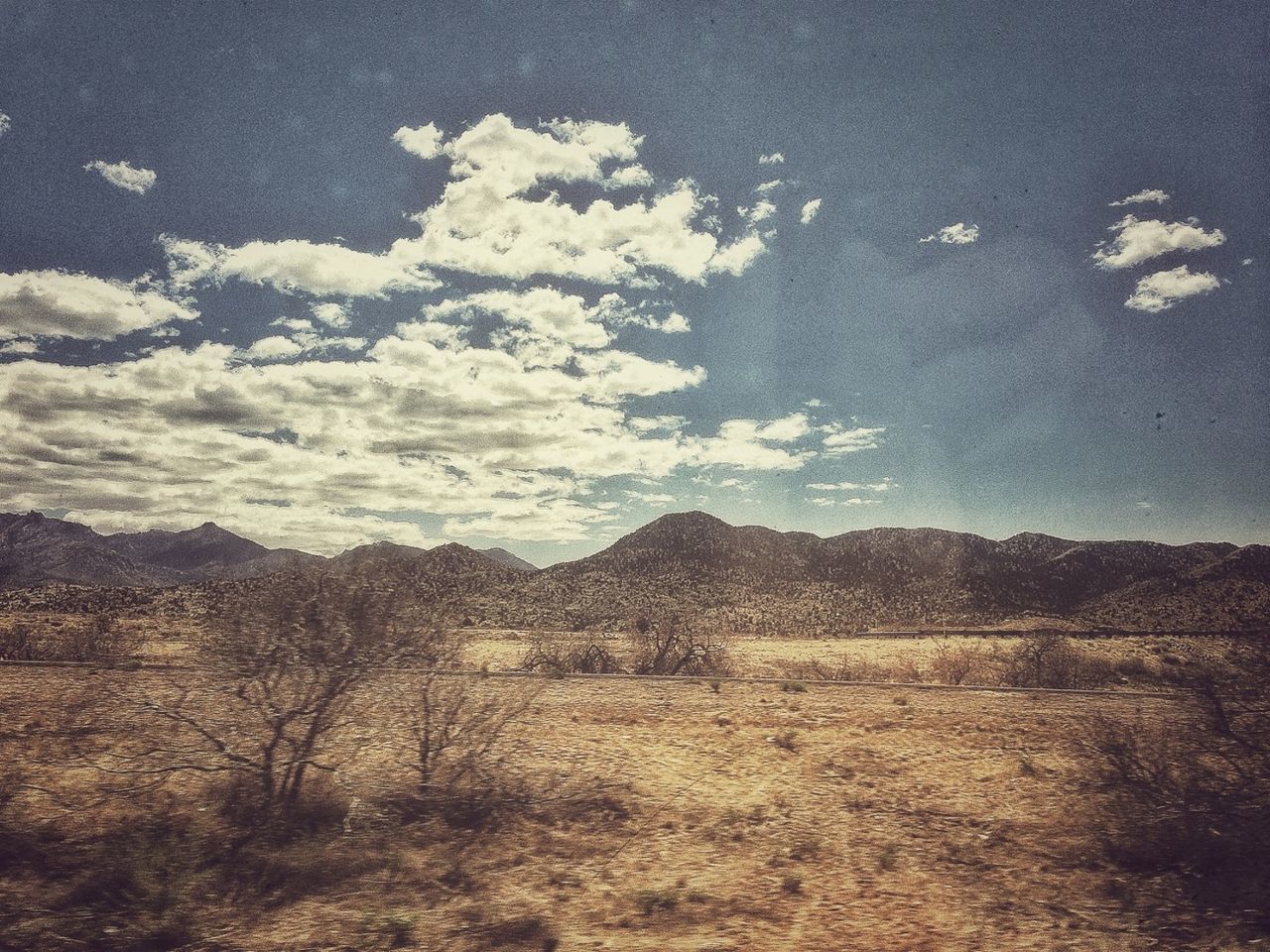 landscape, tranquil scene, tranquility, sky, scenics, mountain, nature, beauty in nature, non-urban scene, field, horizon over land, remote, cloud - sky, mountain range, grass, cloud, desert, day, solitude, hill