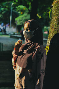 Woman looking away while standing outdoors