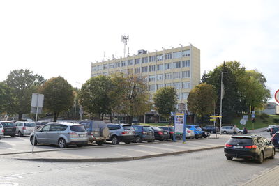 Cars on road against sky in city