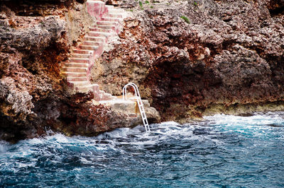 High angle view of water flowing through rocks at staircase