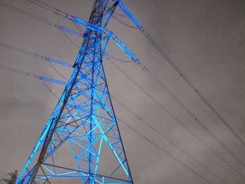 Low angle view of electricity pylon against blue sky