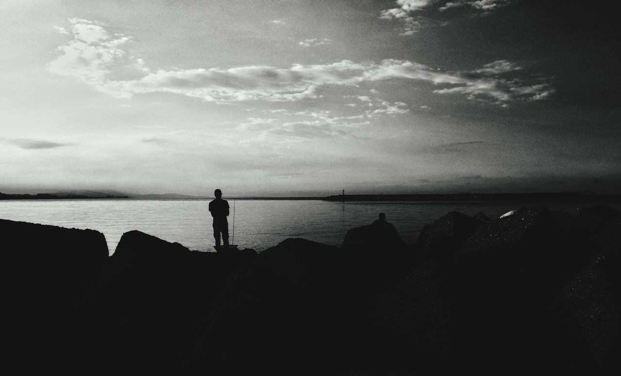 SILHOUETTE MAN STANDING ON BEACH