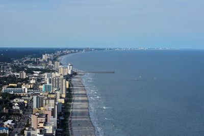 Aerial view of cityscape by sea against clear sky