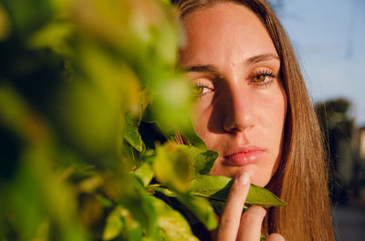 Close-up of young woman against plants