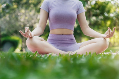 Low section of woman exercising on field