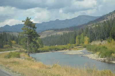 Scenic view of river and mountains against sky