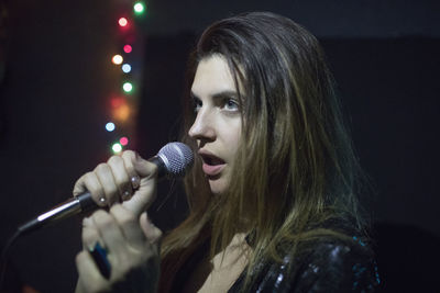 Young woman singing at band rehearsal