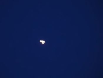 Low angle view of moon against blue sky