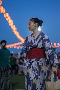 Young woman standing against clear blue sky