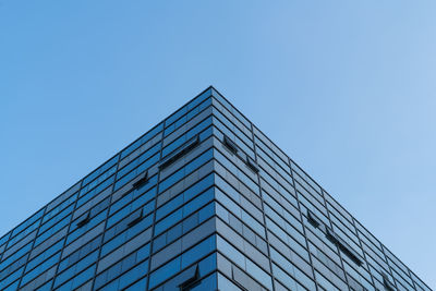 Low angle view of modern building against clear blue sky