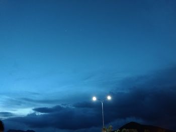 Low angle view of illuminated street light against sky