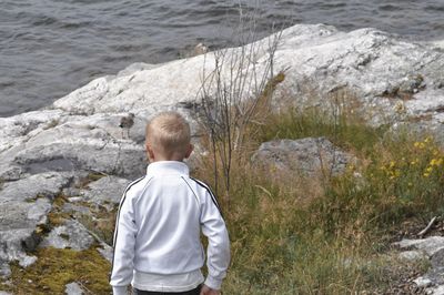 Rear view of boy looking at sea shore