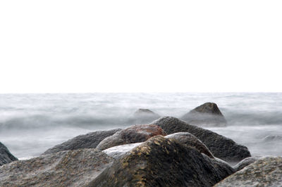 Rocks on beach against sky