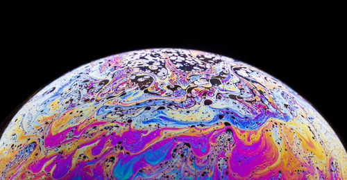 Close-up of multi colored water over black background